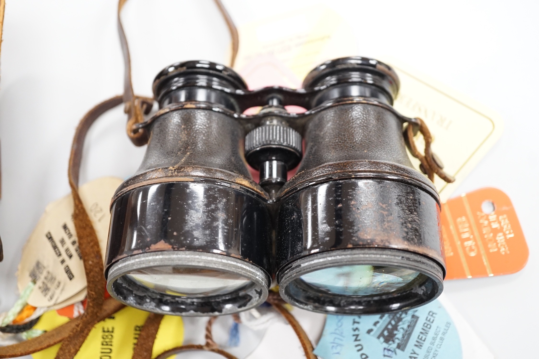 A pair of French binoculars in case, with various race meeting badges